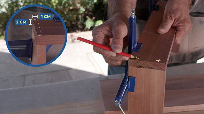 Una persona marca las fijaciones de las repisas del organizador para baño