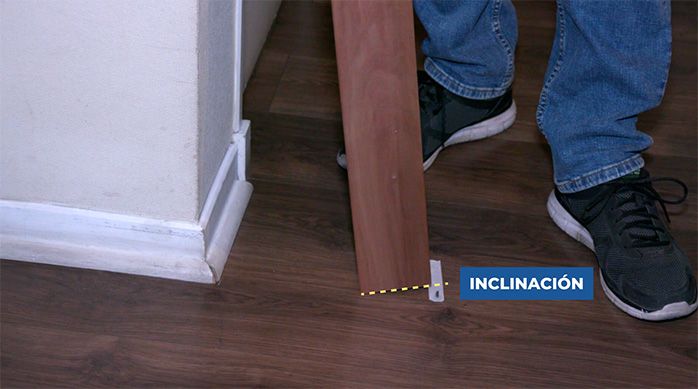 Una persona presenta la tabla de madera en la marca con cinta de enmascarar
