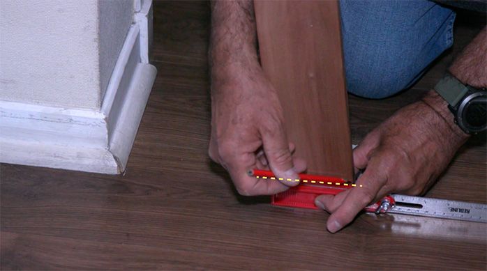 Una persona marca la tabla de madera en su parte inferior