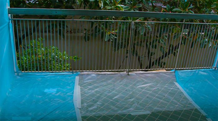 Terraza o balcón cubierto con plástico antes de la reparación de la baranda metálica