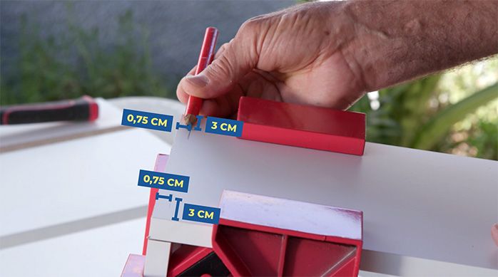 Una persona marca el lugar de las fijaciones para armar los cajones del mueble organizador de artículos de limpieza