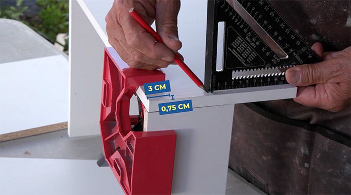 Una persona marca las fijaciones del cajón del mueble organizador