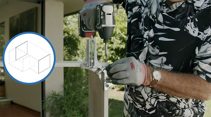 Una persona atornilla la unión entre las melaminas con un desatornillador eléctrico, usando guantes 3m