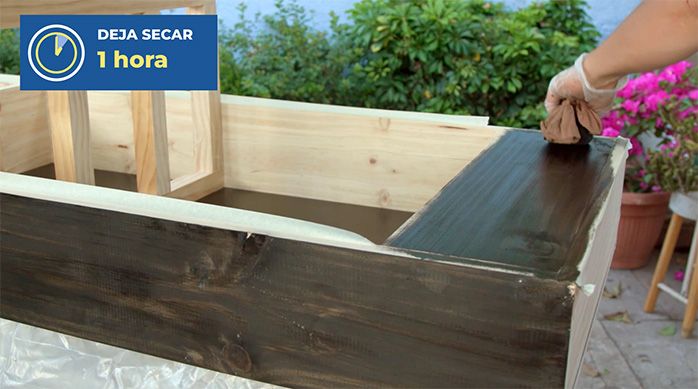 Una persona aplica tinte para madera con una muñequera en la estación de café o té