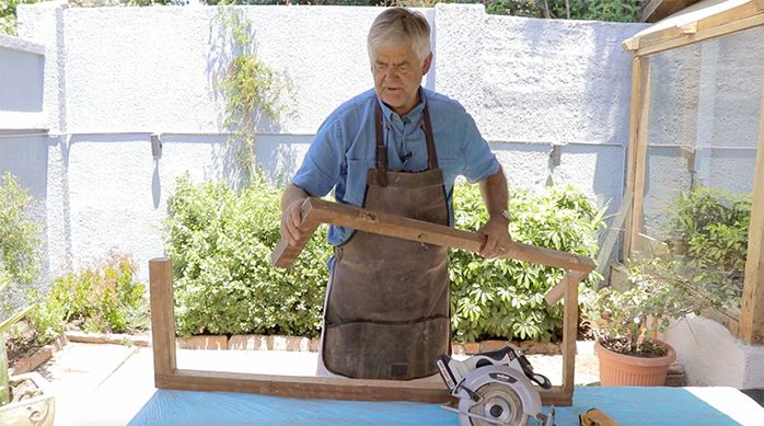 un hombre con un marco de madera desarmado