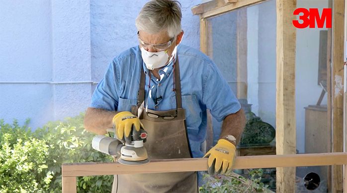 un hombre lija el marco de madera del escritorio home office