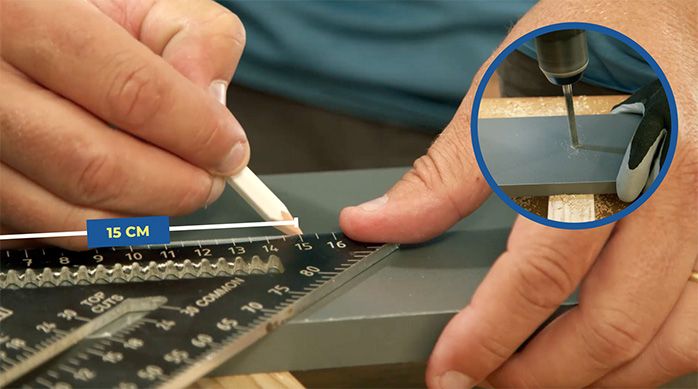 una persona marca con una escuadra el lugar de fijación en la melamina