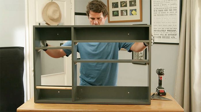 una persona muestra el escritorio plegable de pared