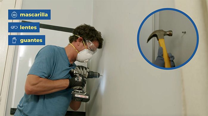 una persona perfora la pared para instalar el escritorio plegable