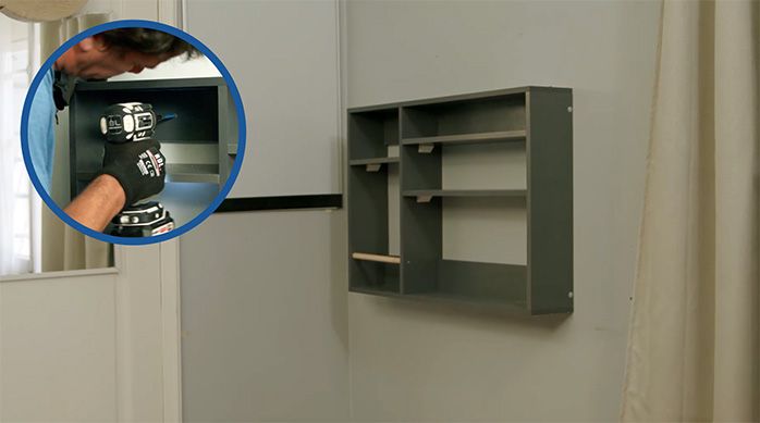 una persona atornilla el escritorio plegable a la pared