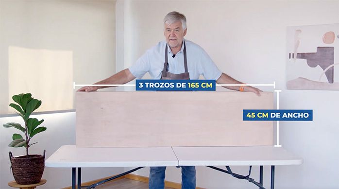 un hombre muestra unas planchas de terciado marino