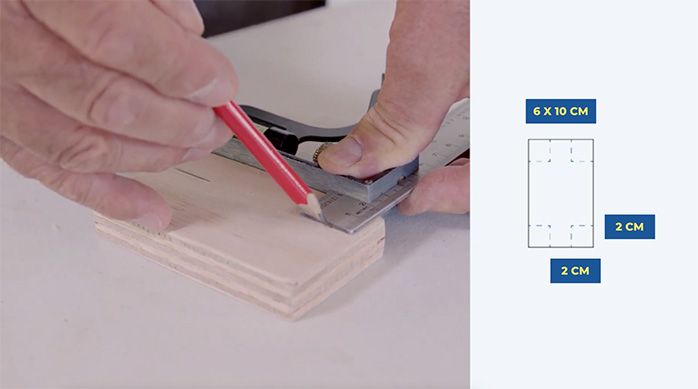 un hombre marca 4 perforaciones en la base del separador de ambientes plegable