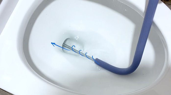 una sonda destapadora en la salida de agua de un inodoro