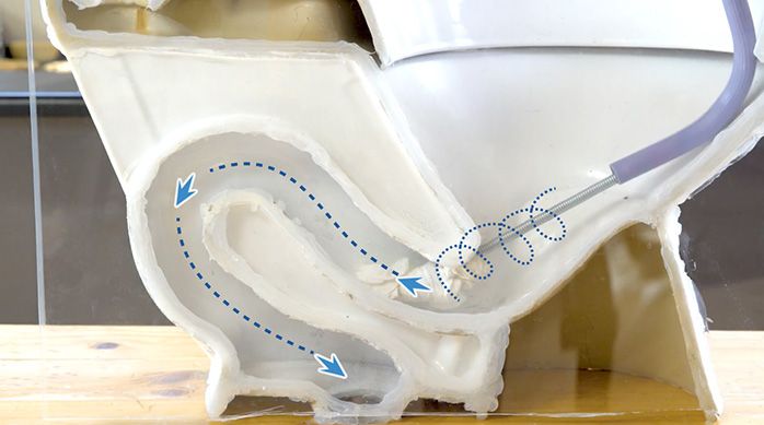 un inodoro con una sonda destapadora en su interior para destapar un wc