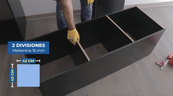 un hombre presenta 2 divisiones por dentro del cajón de melamina para armar el mueble gamer