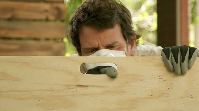 un hombre limpia el calado en la cubierta de la mesa plegable de madera