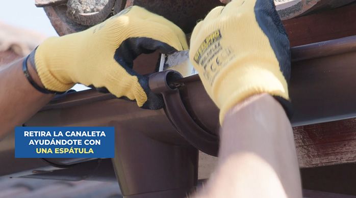 un hombre desmonta una canaleta de pvc con las manos