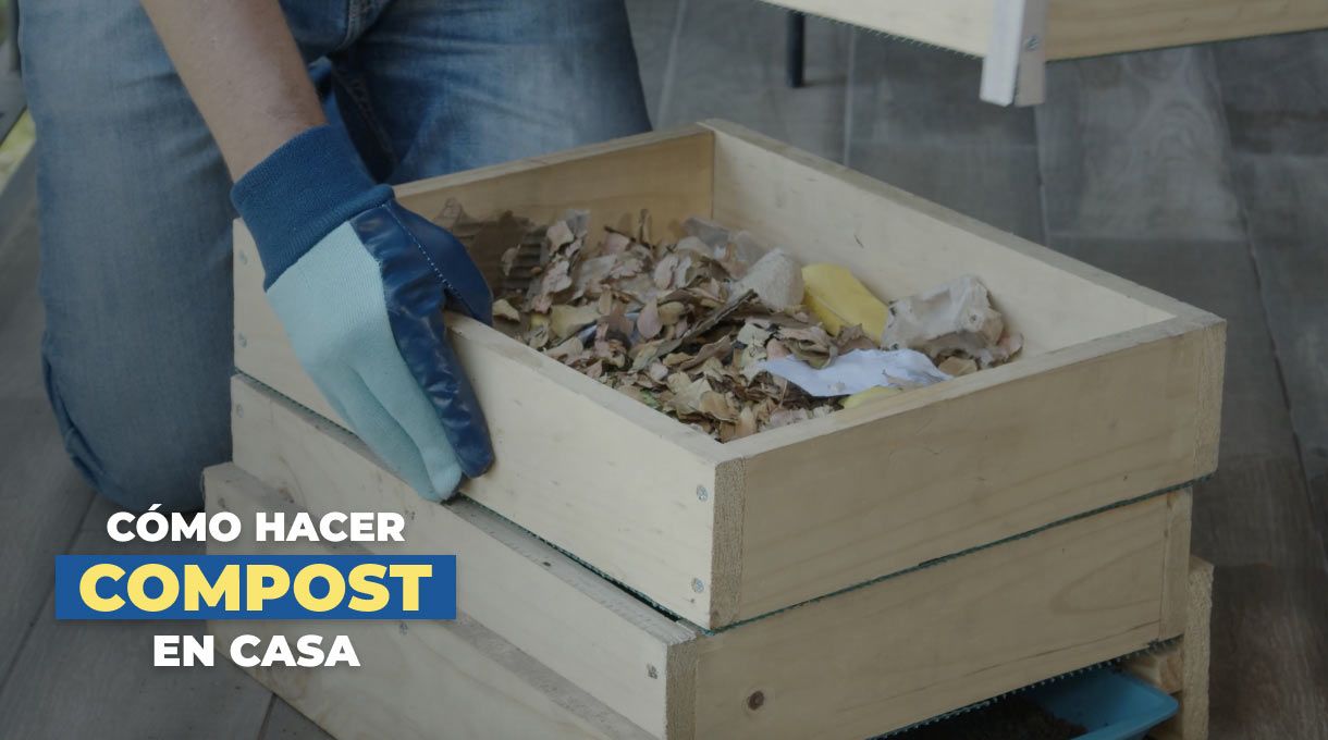 una persona con una compostera de madera para enseñar a cómo hacer compost en casa
