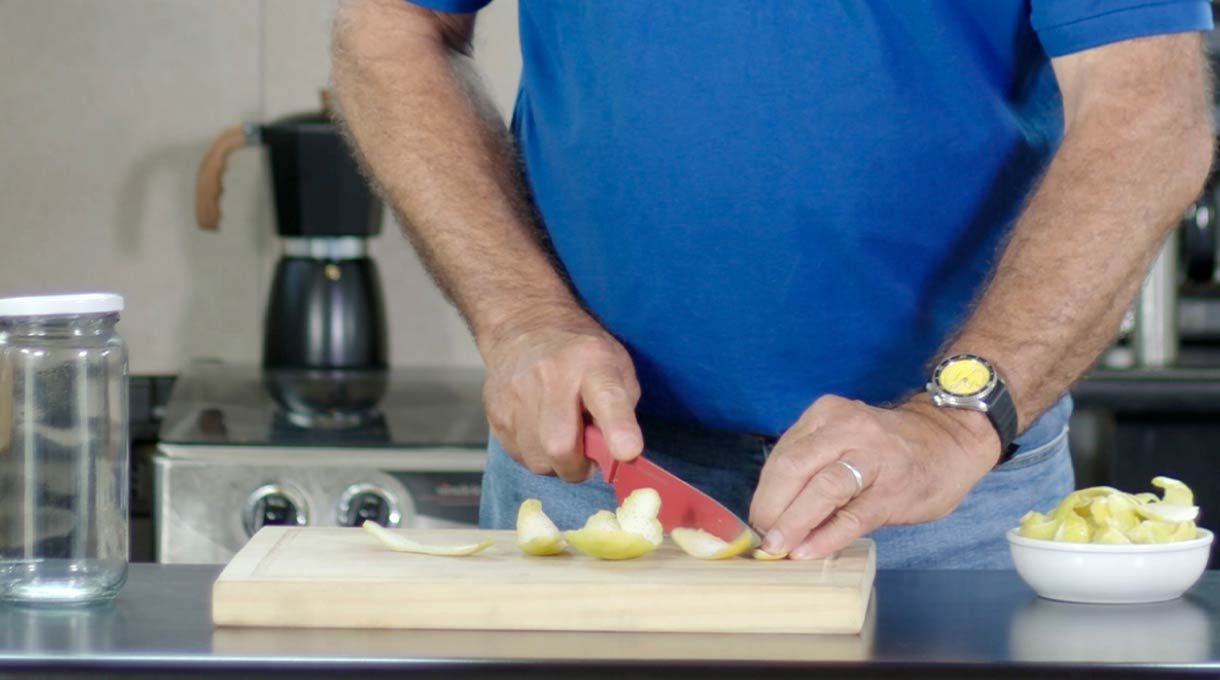 un hombre corta cáscaras de limón en una cocina