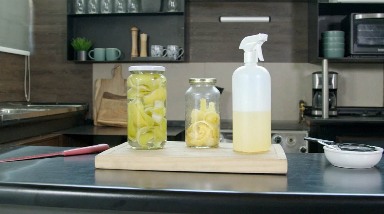 se ve el desengrasante natural hecho de cítricos y vinagre en una cocina