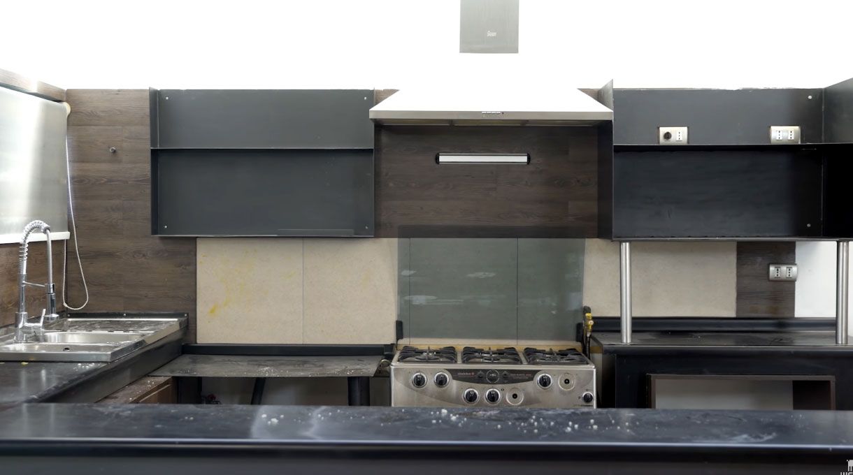 Una cocina de tonos café oscuro y plomo sucia