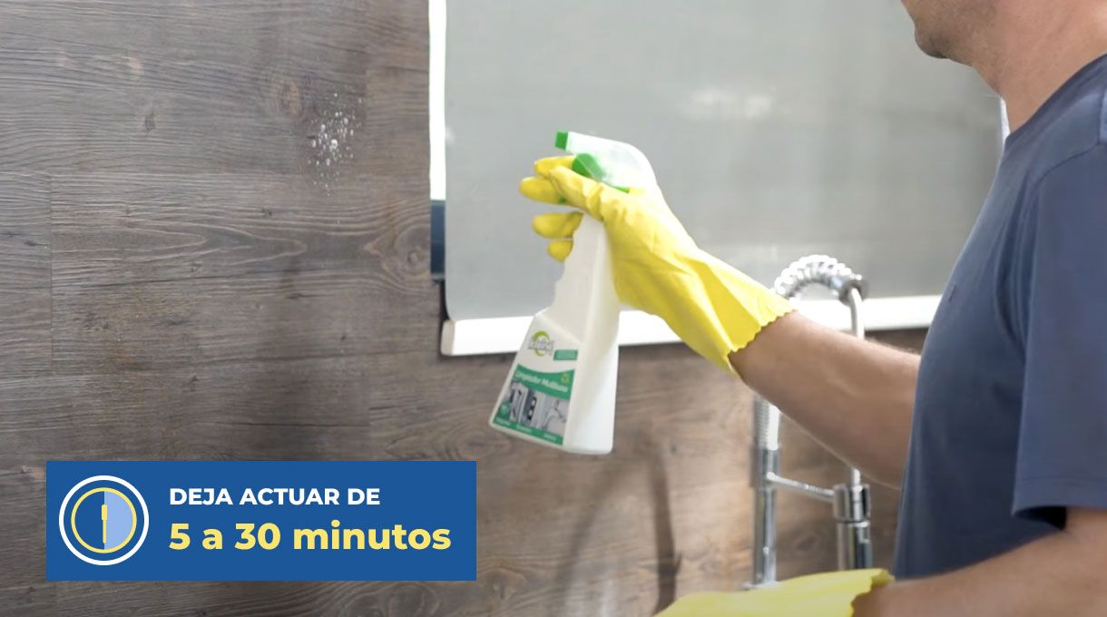 un hombre rocía un removedor de grasas para limpiar la cocina