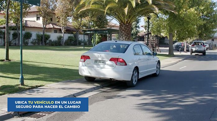 un auto blanco estacionado en la vereda de una calle