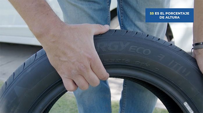 un hombre indica con la mano la altura del neumático