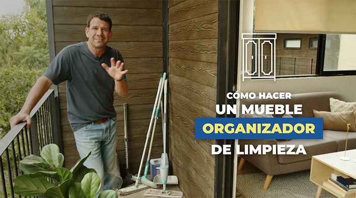 un hombre en el balcón de un departamento con artículos para limpieza