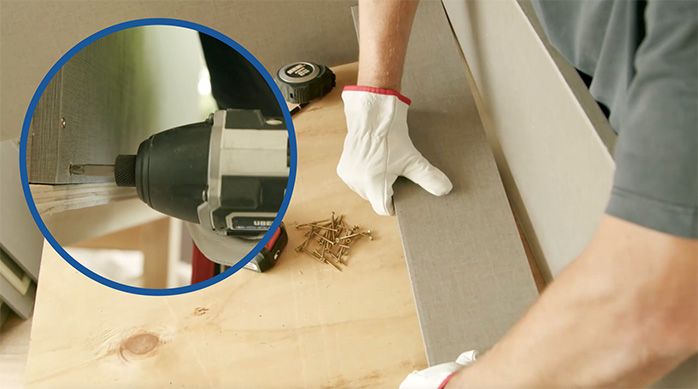 un hombre fija los refuerzos del mueble organizador de artículos de limpieza