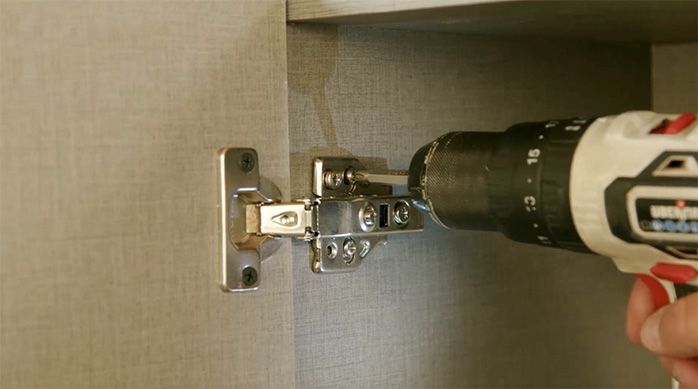 un hombre fija las puertas del mueble organizador
