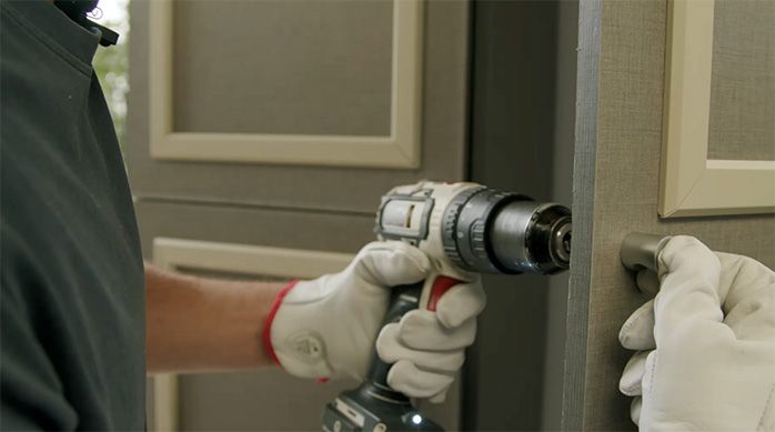un hombre instala perillas o tiradores en las puertas del mueble organizador para limpieza