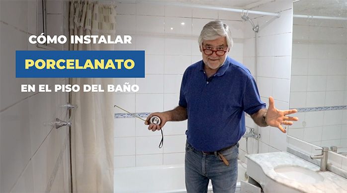 un hombre en un baño con muros de cerámica blanca