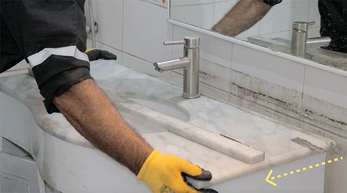 un hombre retira el vanitorio del baño