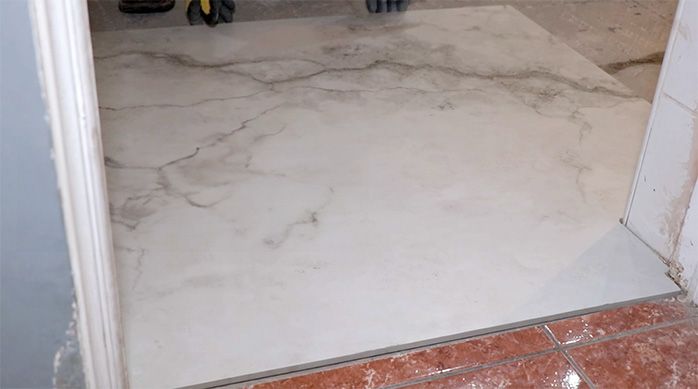 una plancha de porcelanato para baños puesta en la entrada de un baño