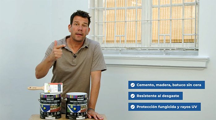 un hombre presenta una pintura acrílica especial para pintar un piso de cemento