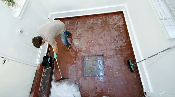 un hombre usa un seca pisos para secar el piso de cemento