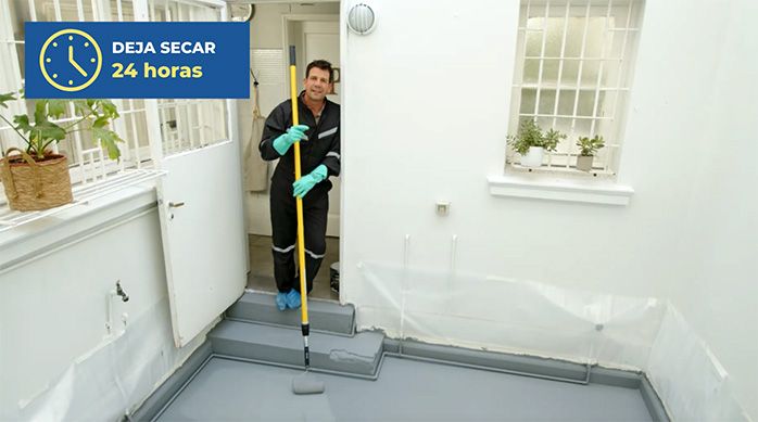 un hombre en un patio techado con el piso de cemento recién pintado