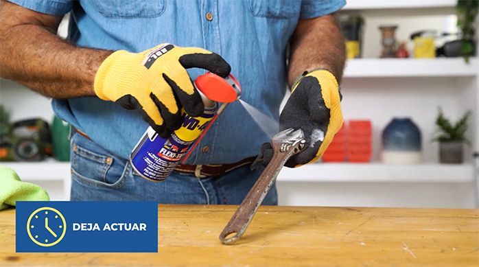 un hombre aplica wd-40 flexitapa en la herramienta oxidada
