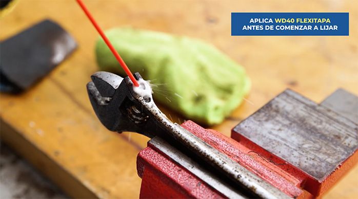 una persona aplica wd-40 en una herramienta para quitar el óxido