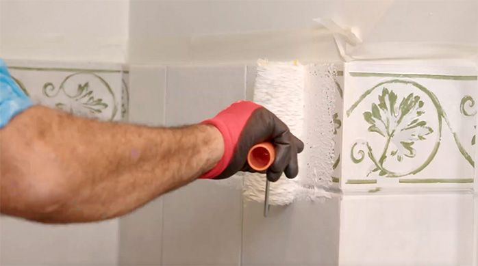 un hombre pinta el baño de visitas con un rodillo
