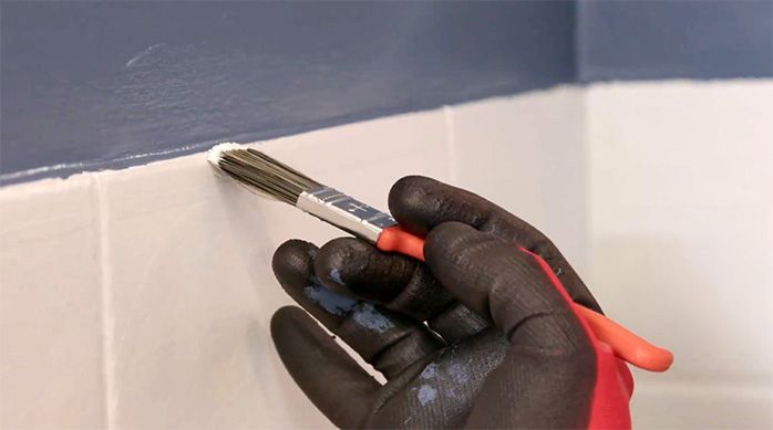 una persona corrige los detalles de pintura con una brocha