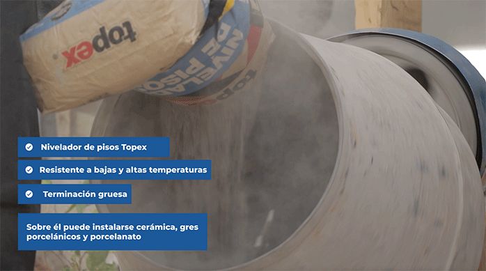 una persona abre un saco de nivelador de pisos topex en una betonera