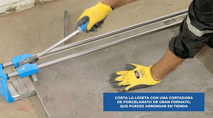 un hombre usa un cortador de porcelanato para cortar el porcelanato para piso