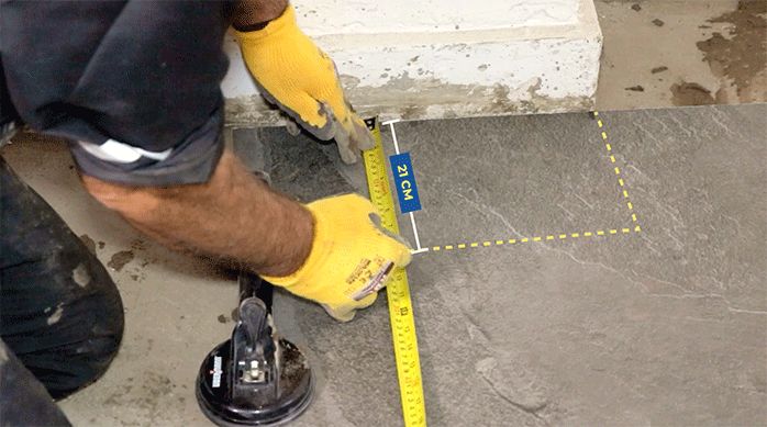 un hombre marca el corte en un porcelanato para piso