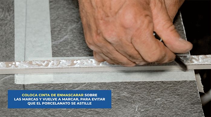 un hombre marca el corte en un porcelanato