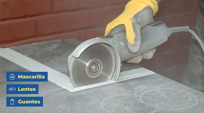 una persona corta el porcelanato para piso con un esmeril angular con disco diamantado