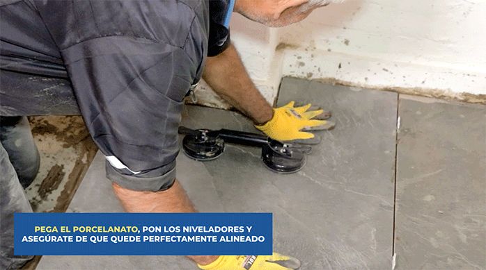 una persona pega el porcelanato para piso en el piso de un comedor