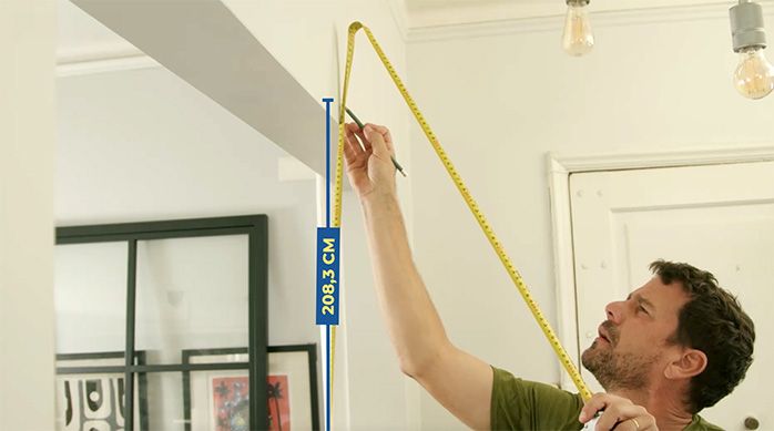 un hombre mide la altura necesaria para instalar una puerta corredera