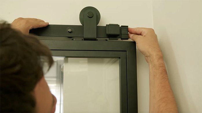 un hombre pone un tope de goma en el riel para puerta corredera